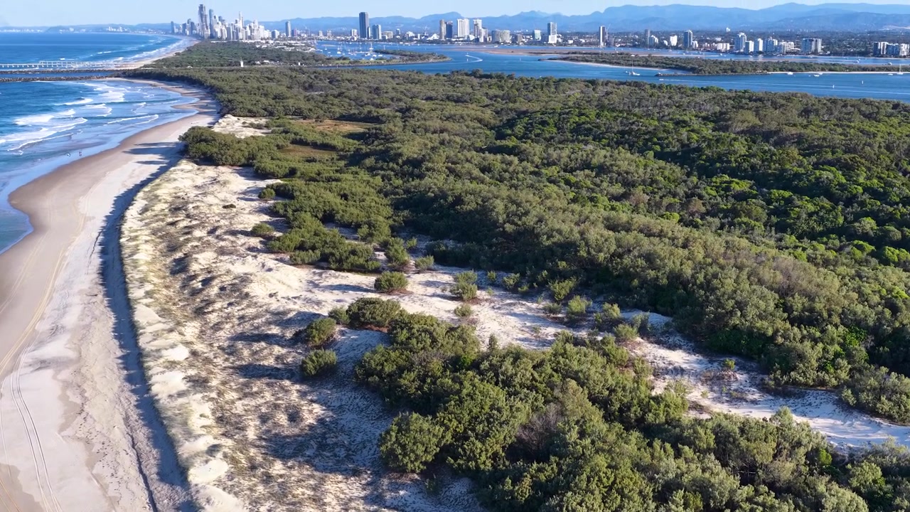 Riprese con drone mostrano dune di sabbia, foresta e onde oceaniche a South Stradbroke Island, Australia