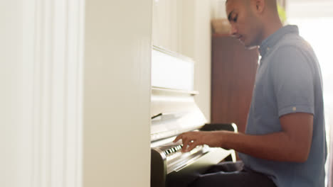 Hombre-Birracial-Tocando-El-Piano-En-Casa,-Cámara-Lenta