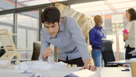 ejecutivo trabajando en un modelo arquitectónico en la oficina 4k