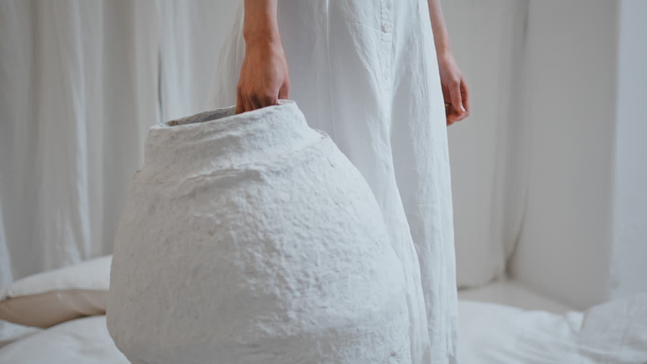 un artista de primer plano con una jarra en la mano. un diseñador creativo decorando un apartamento en casa.