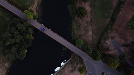 birds eye view, coming down shot above river bridge of a car crossing in the countryside, great bartford, st neots, cambridgeshire, uk