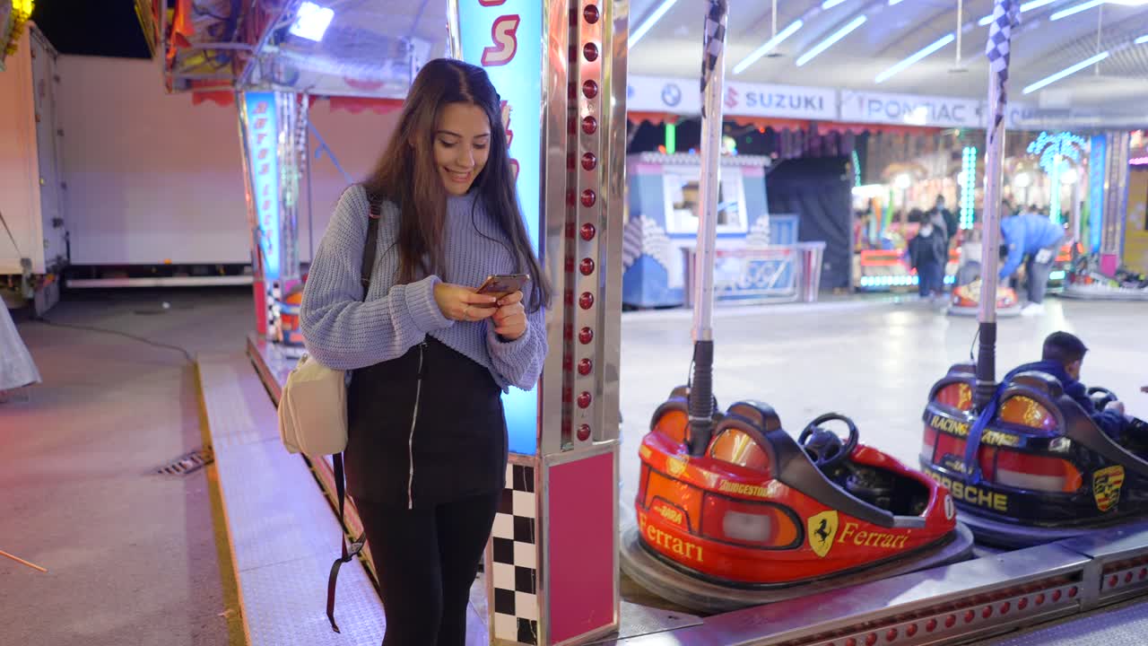 Teenager using phone at a fair