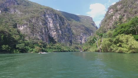 barco navegando en el río grijalva pasando otro barco justo antes de la entrada al cañón del sumidero, chiapas, méxico