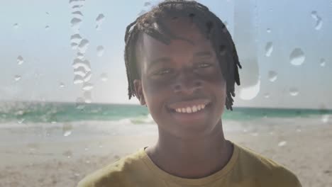 Animation-of-smiling-african-american-man-at-sunny-beach-over-droplets