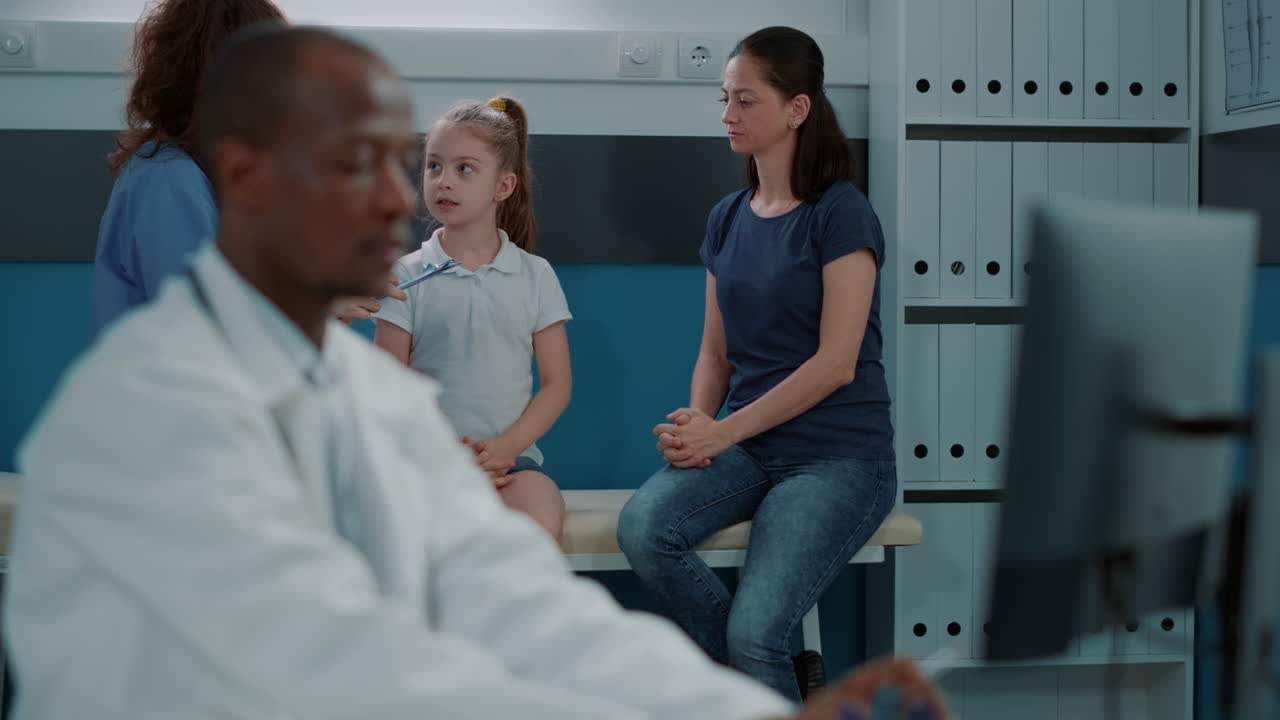 Child Patient and Mother in Clinic with Doctor