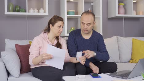 happy married couple calculating their debts and bills together.