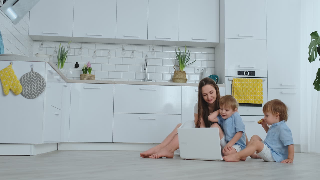 두 명의 어린 자녀를 둔 진보적인 젊은 어머니가 비디오 통신을 통해 아버지와 이야기하고 있습니다. 현대 기술은 젊은 가족입니다.