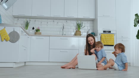 una joven madre progresista con dos hijos pequeños está hablando con su padre a través de la comunicación por video. la tecnología moderna es una familia joven.