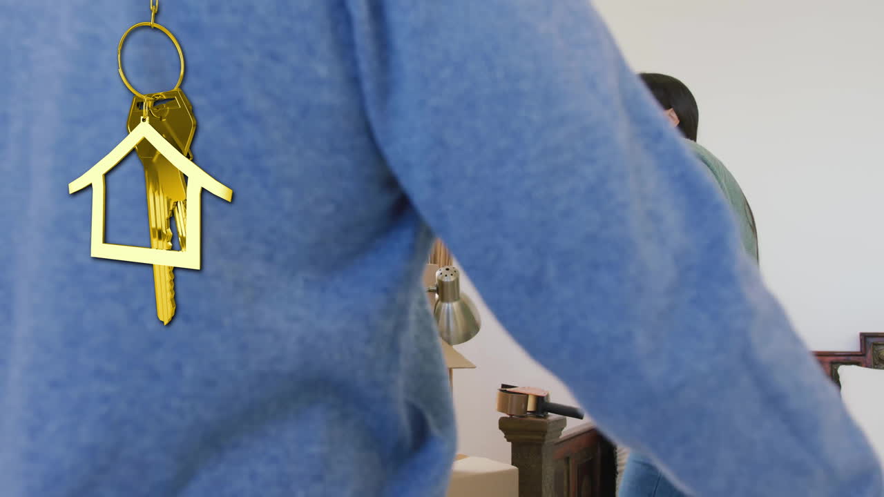 animación de la llave de la casa de oro y el llavero sobre una pareja diversa desempaquetando en la nueva casa