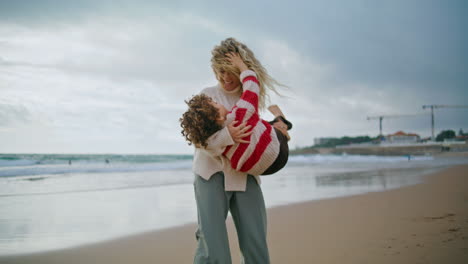 madre feliz divirtiéndose con su lindo hijo en la playa del océano. familia alegre jugando