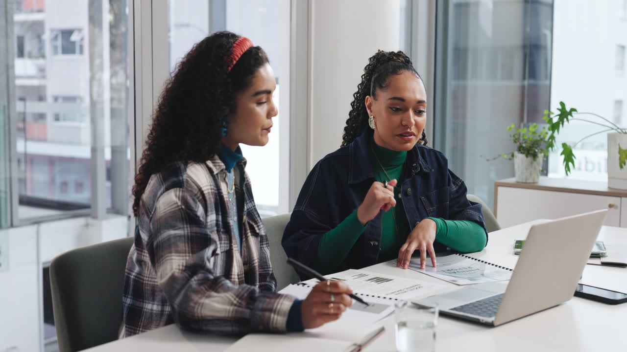 Two businesswomen collaborating on a project in the office