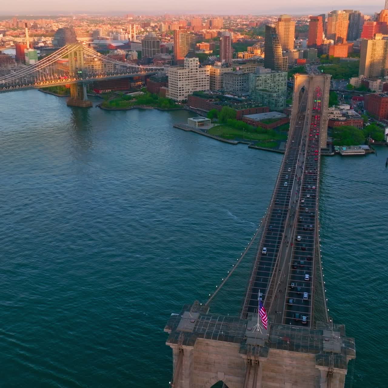 Wonderful Brooklyn Bridge with its heavy traffic. Beautiful yacht cutting the smooth surface of blue East River waters. Incredible view of sunlit New York cityscape