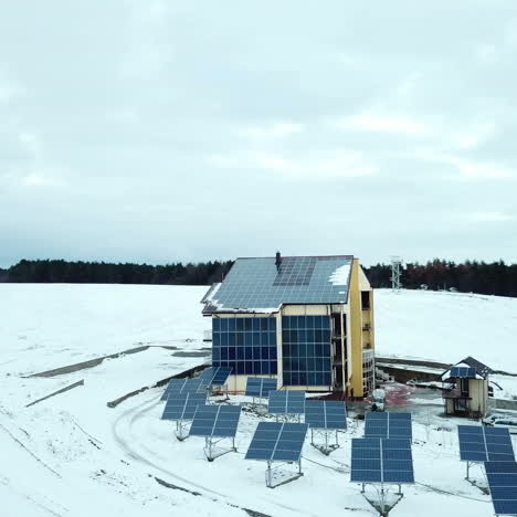 aerial solar farm low flight in winter. series of solar panels covered with snow.