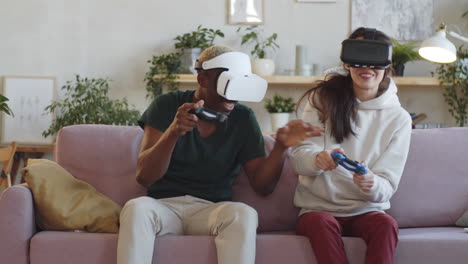 multiethnic couple in vr headsets playing console game at home