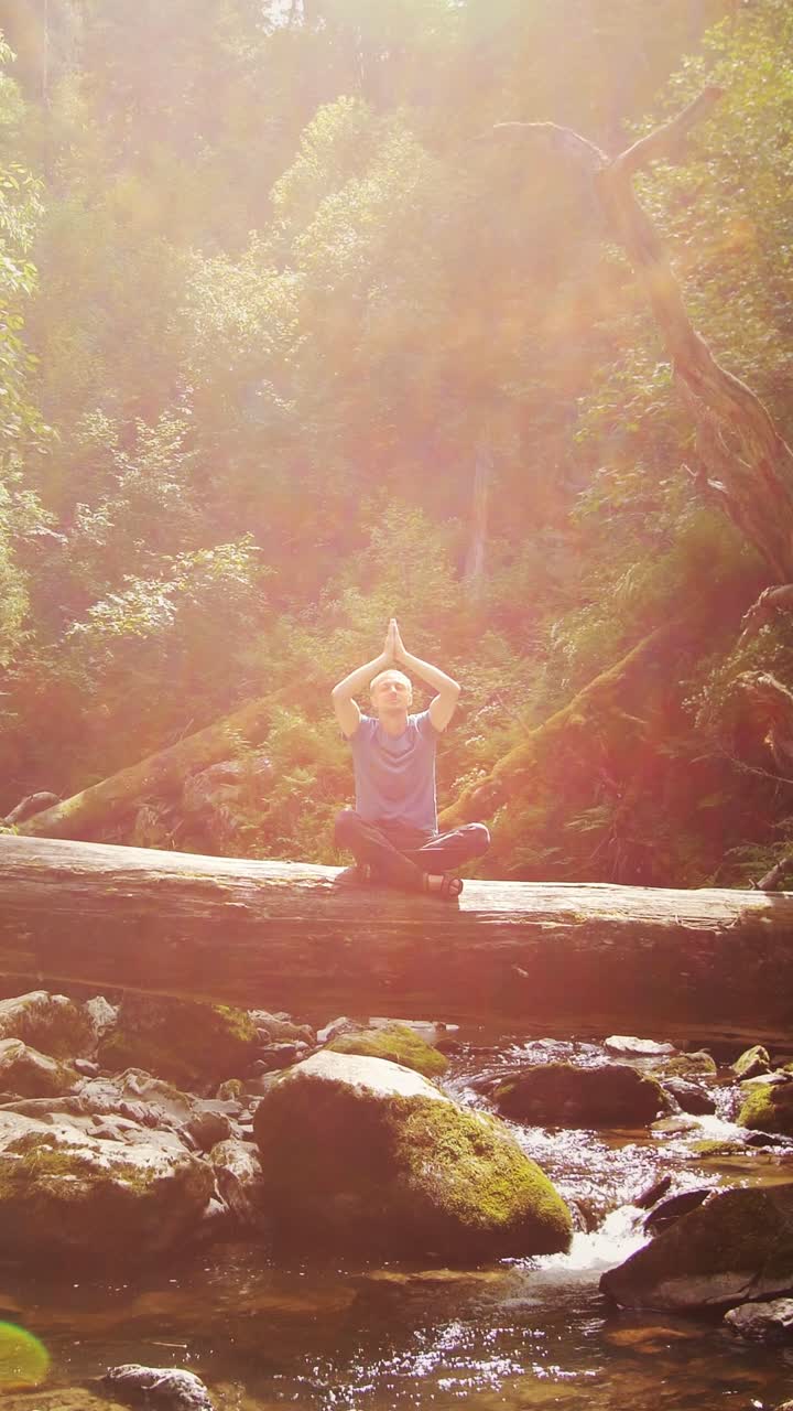 Man meditating in a forest by a stream