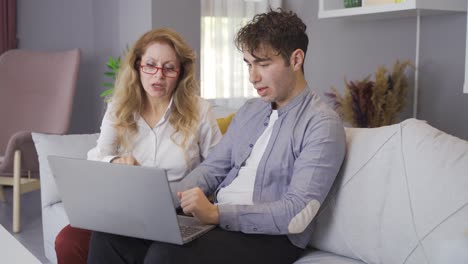 young man showing something from laptop to his mother.