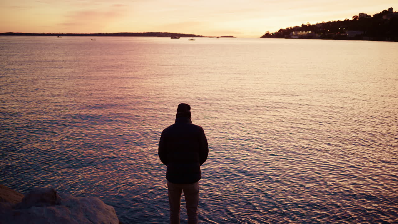 Silhouette of a man fishing in the calm Mediterranean Sea at sunrise in the South of France