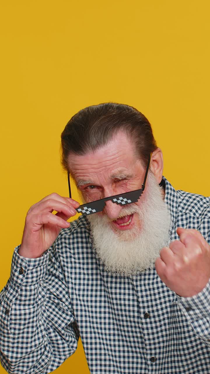 un anciano feliz con elegantes gafas de sol escuchando música bailando en una discoteca celebrando la victoria