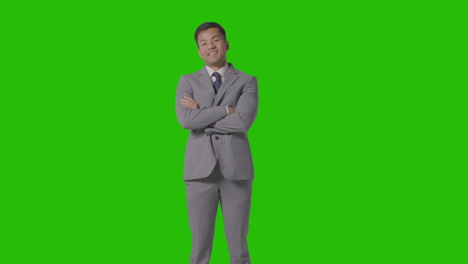 retrato de tres cuartos de longitud de un hombre de negocios en traje contra una pantalla verde sonriendo a la cámara 2