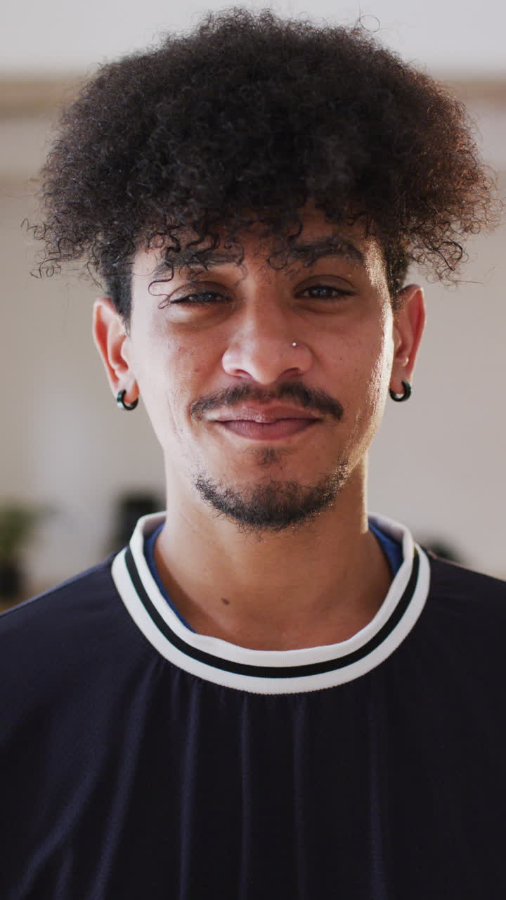 Vertical video of portrait of happy biracial man in dance studio