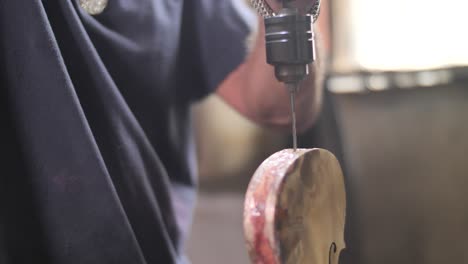 luthier drills in violin body, creating handmade classic music instrument