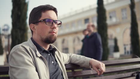 man sitting on a bench in a park