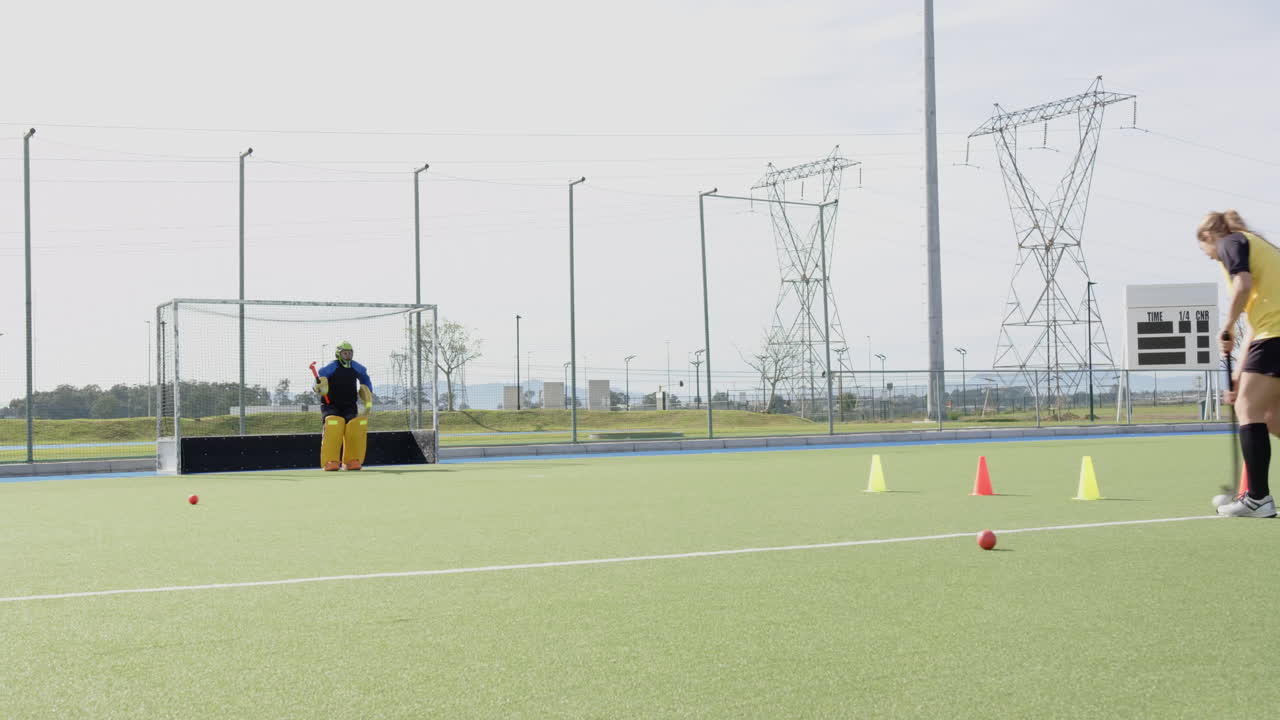 Female hockey player practicing shots on goal with focused determination