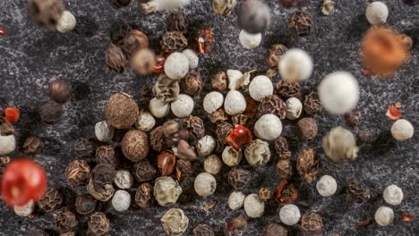 mixed peppercorns in a super slow motion. dry mix peppercorns close up.