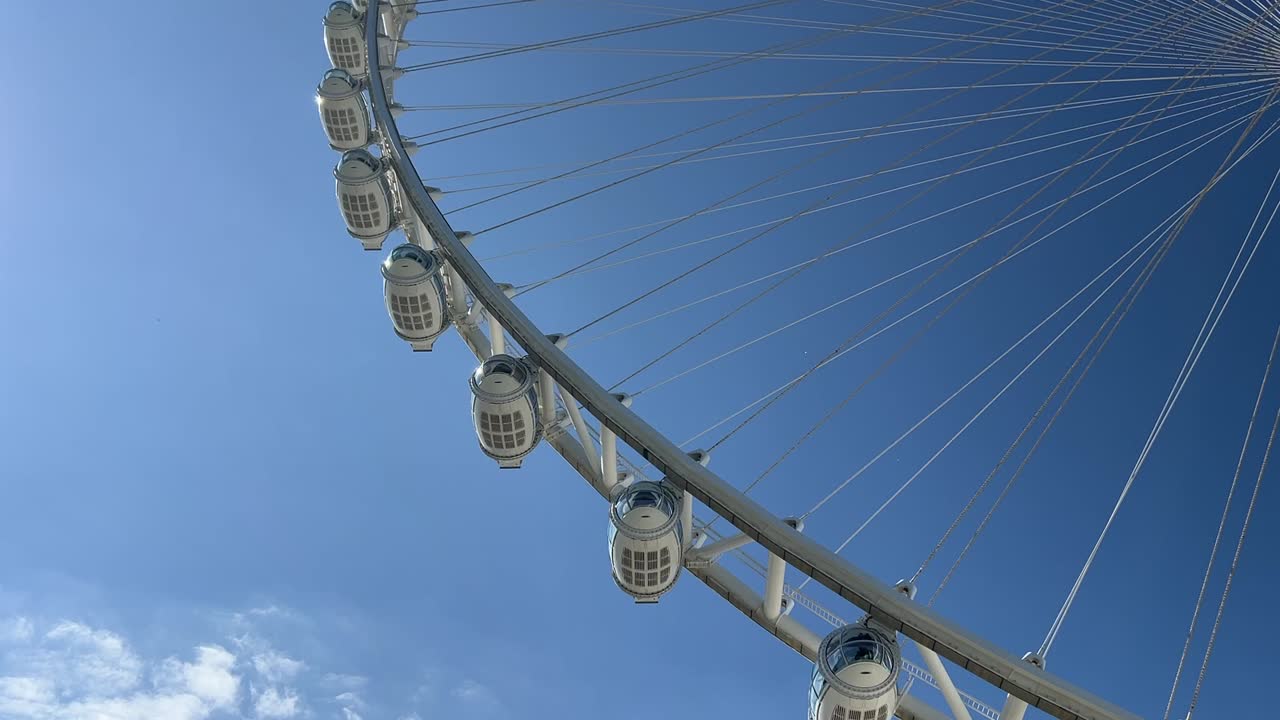 Sky view of the dubai aie wheel slowly moving as the sun shines.