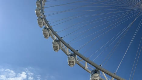 sky view of the dubai aie wheel slowly moving as the sun shines.