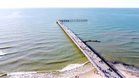 aerial static view of palanga bridge with people and calm baltic sea