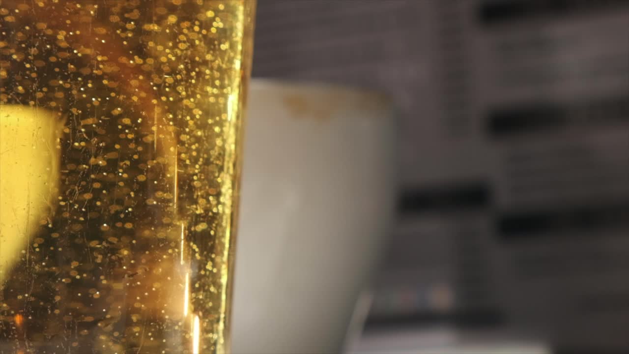 vista macro de burbujas de cerveza y espuma en vidrio contra un telón de fondo borroso