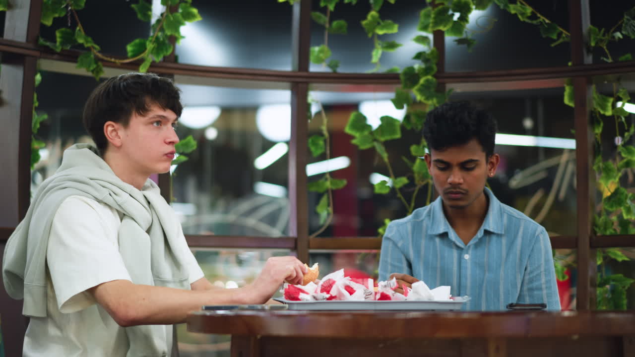 Young person chewing snack while focusing on food with radiant light beams surrounding scene, warm glow highlighting hands and chips, casual break moment sharing enjoyment and texture