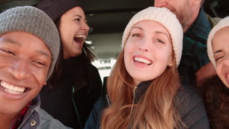 happy friends in open hatchback of a car, head and shoulders