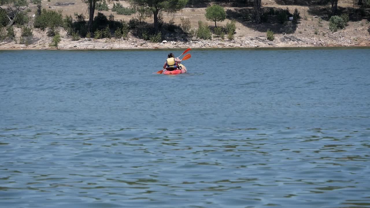 Two people paddling on kayak at pantano de San Juan lake, Madrid