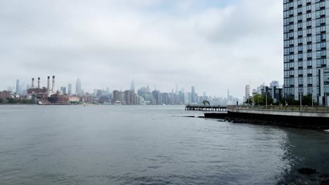 North-Williamsburg-Pier-An-Einem-Düsteren-Morgen-Mit-Blick-über-Den-East-River-Auf-Die-Skyline-Von-Manhattan-Mit-Dem-Empire-State-Building-In-Wolken