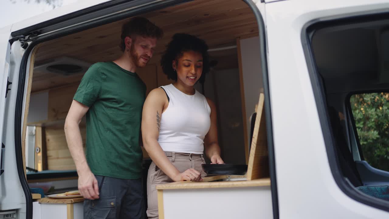 Couple cooking in camper van