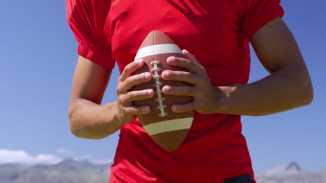 american football player holding a ball