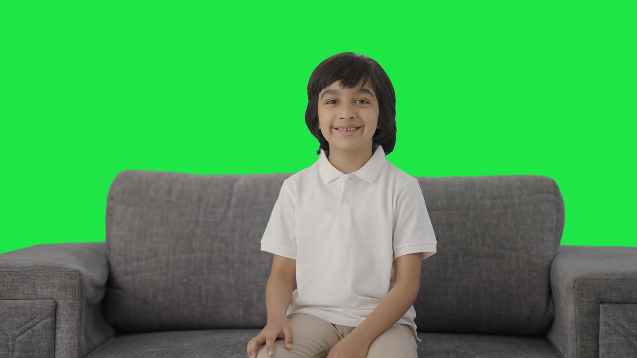 niño indio feliz sonriendo a la cámara pantalla verde