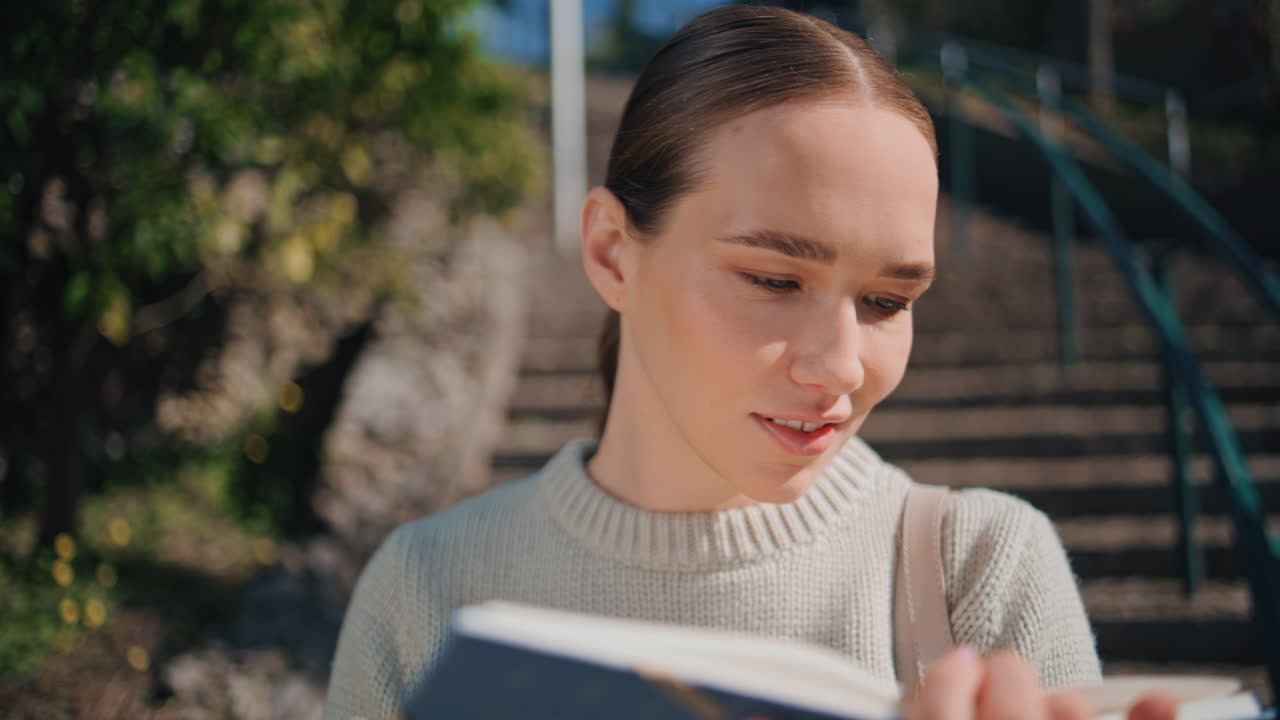 Smart student flipping book at sunshine staircase closeup. Happy woman relaxing