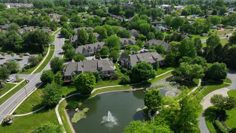 Panoramablick-Auf-Eine-Private-Wohnanlage-Mit-Stadthäusern-Und-Apartmentkomplexen-Mit-Wunderschöner-Landschaftsgestaltung,-Altem-Baumbestand,-Spazierwegen-Und-Einem-See-Mit-Springbrunnen