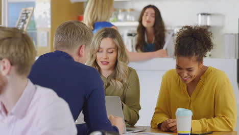 gruppe von geschäftskollegen mit informeller besprechung um den tisch im büro des cafés