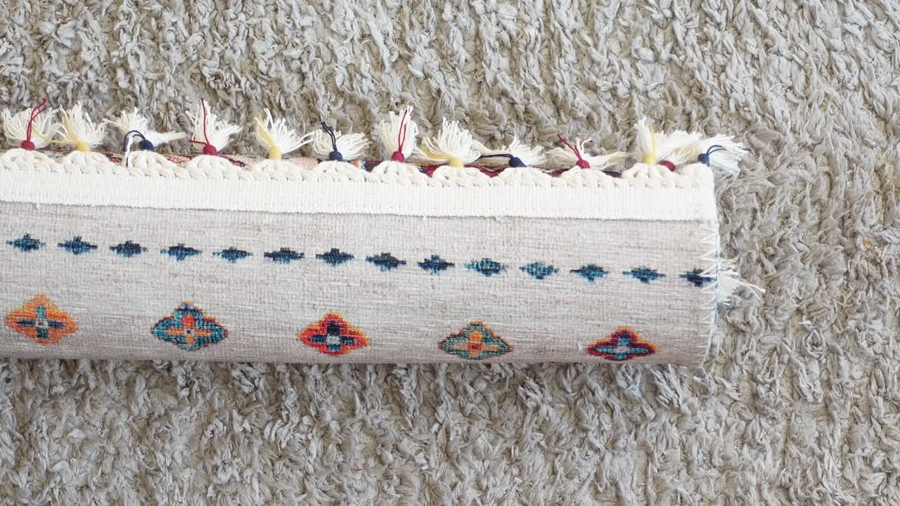 Rolled up patterned rug with tassels