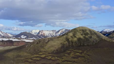 aerial drone ascending view in front of the norðurnámshraun lava field in landmannalaugar, with a small mountain in the foreground