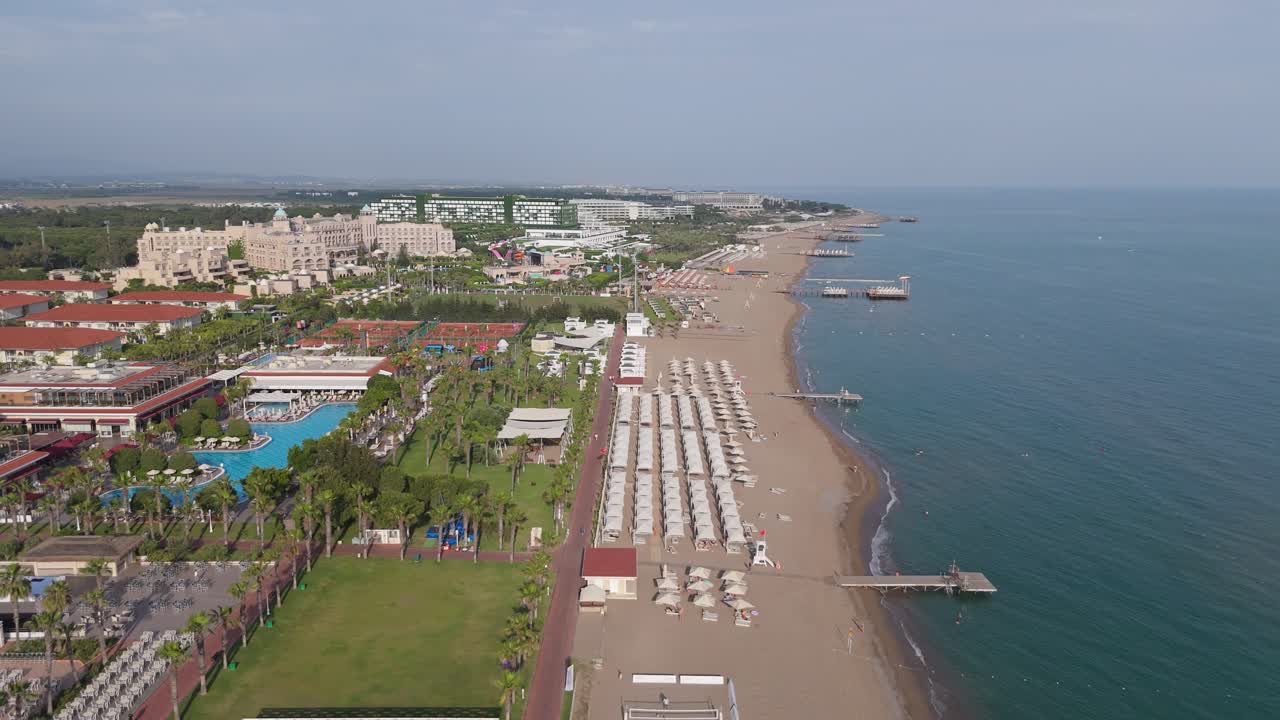 Aerial View 4K Majestic Shores of Belek Beachfront Paradise. Sandy Beaches of the Mediterranean Sea. Belek Holiday Complex With Five Star Hotels. Beach, Sea, Water Sports, Aquapark, Parasailing