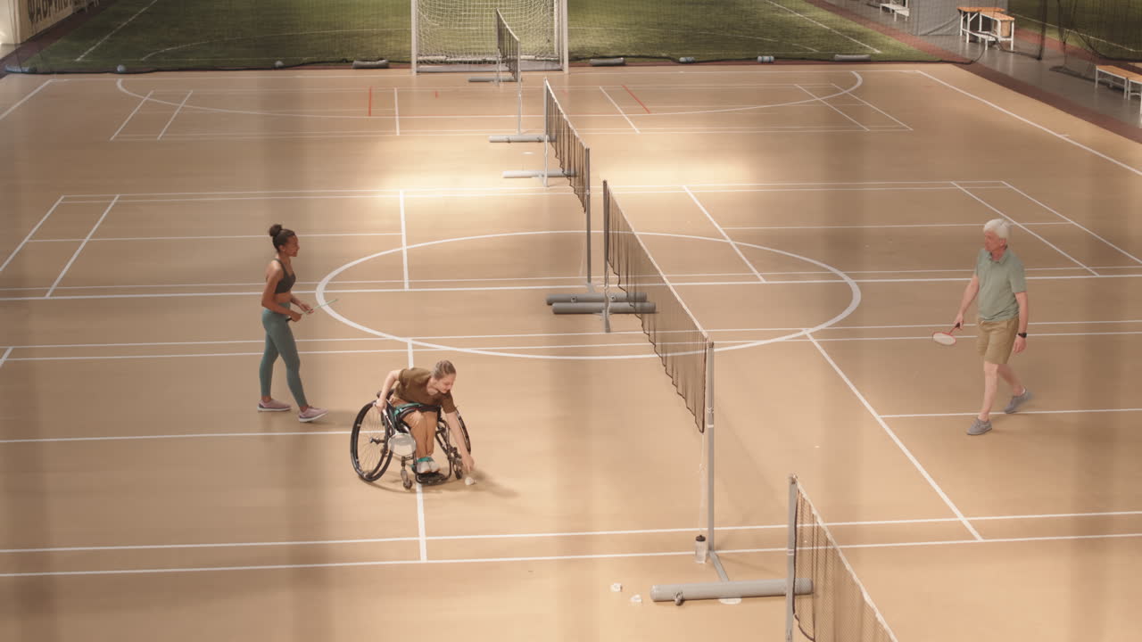 Coach Playing Badminton with Athletes