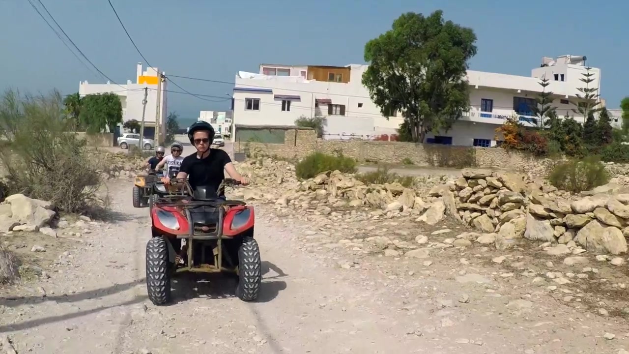 Carrellata di quad nel villaggio di Sidi Kaouki. Guidano su detriti e una strada sterrata.