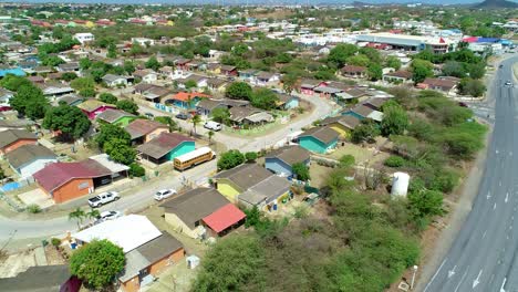 4k tilt up backwards reveal of curacao houses with refinery in background