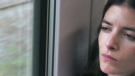 young beautiful woman commuting sitting on moving train passing through nature