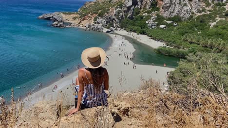 Mädchen,-Das-Vom-Rand-Der-Klippe-Auf-Den-Strand-Von-Preveli---Rethymnon-Blickt-Und-Das-Peace-Zeichen-Zeigt